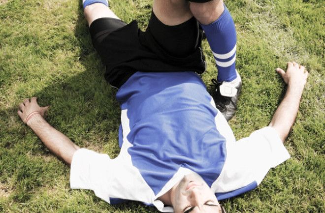 Футболист лежащий на газоне 