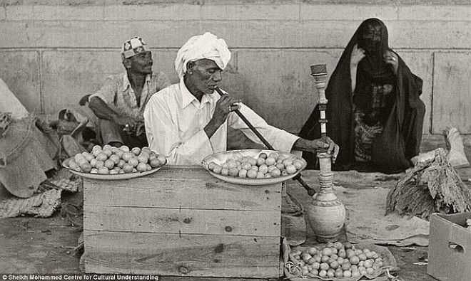 Мужчина, продающий приправы и лимоны, курит кальян, 1960-е